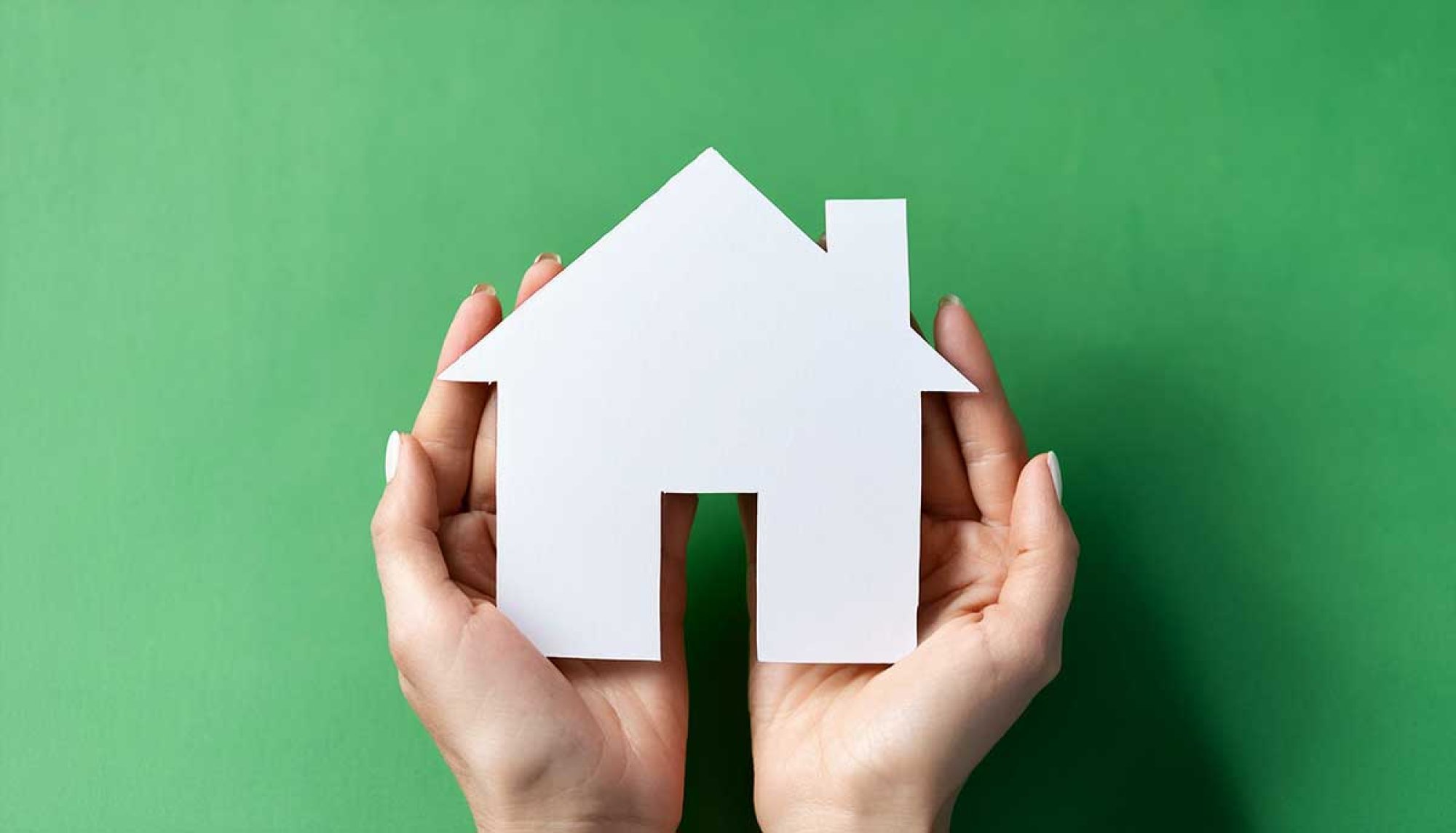 Hände halten Haus aus Papier in der Hand